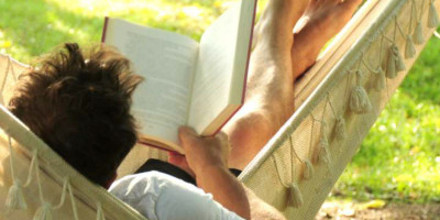 man in hammock reading a book