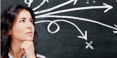 Woman at chalkboard with direction lines going different ways