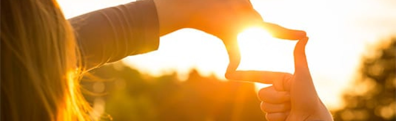 woman surrounding the sun with her hands