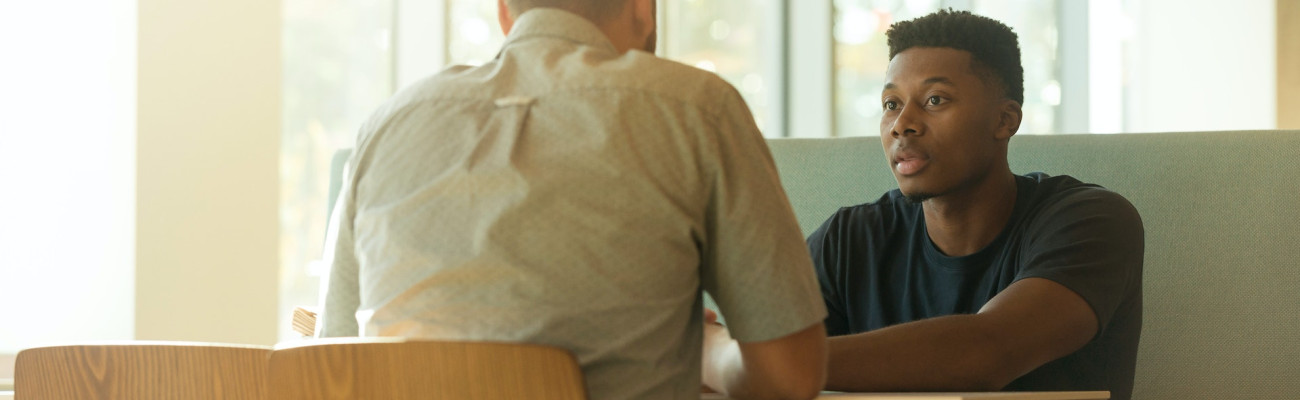 Two men talking at a table