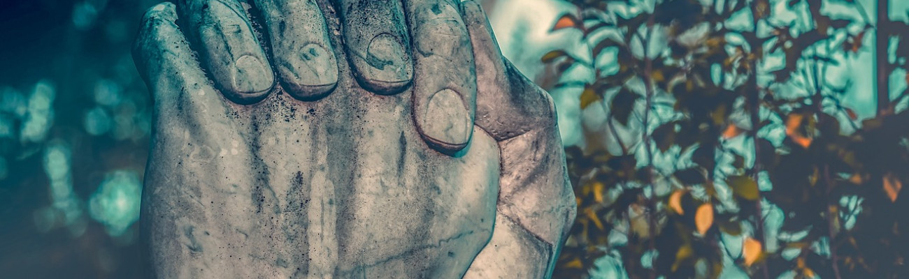 A statue's hands folded praying