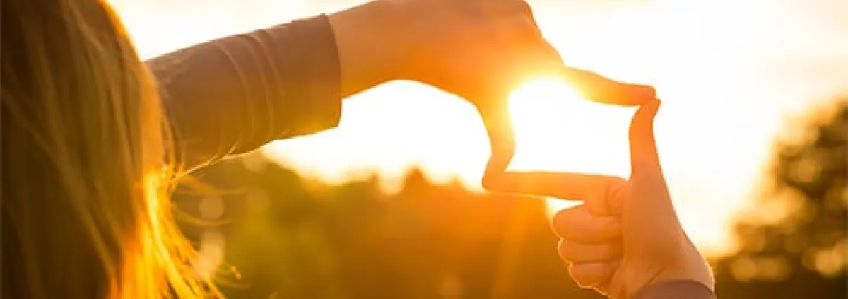 woman surrounding the sun with her hands