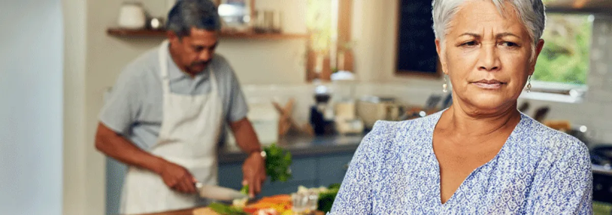 Wife clearly angry while husband is cooking in the background