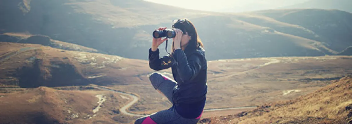 Woman in the hills using binoculars