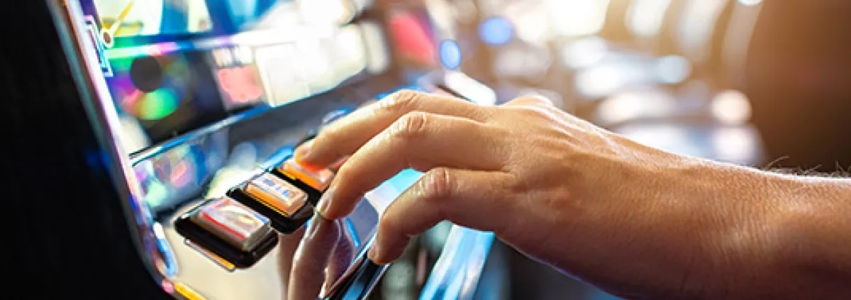hand pushing gambling slot machine button