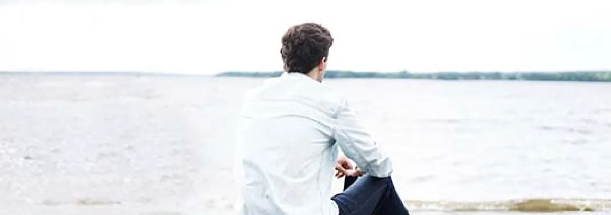 man on the beach looking at the ocean