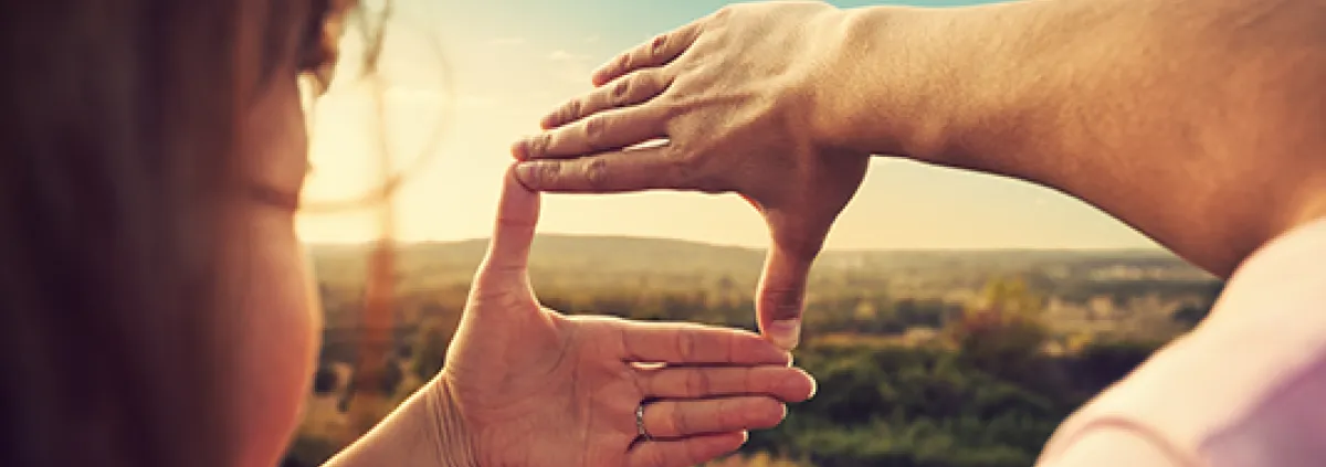 using hands to highlight a section of the countryside for a photo