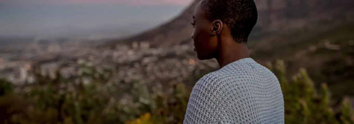 woman on a mountain looking down at the view below