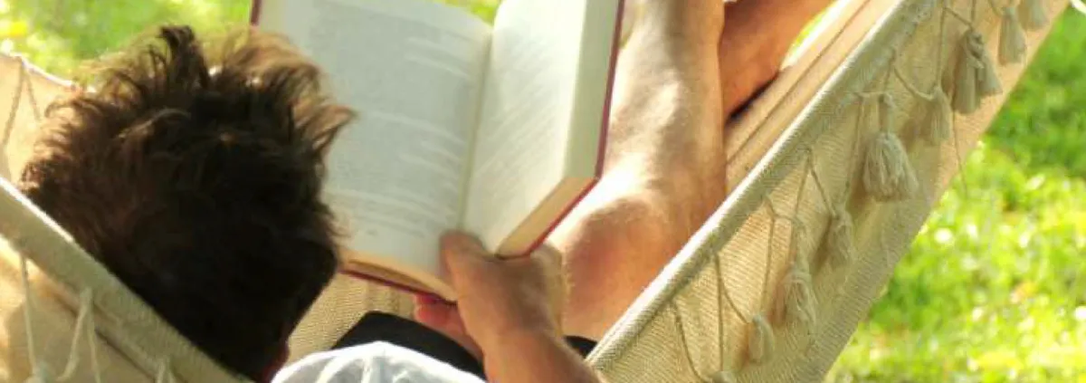 man in hammock reading a book