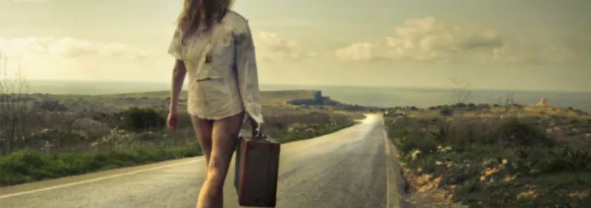 woman walking on the road with a suitcase